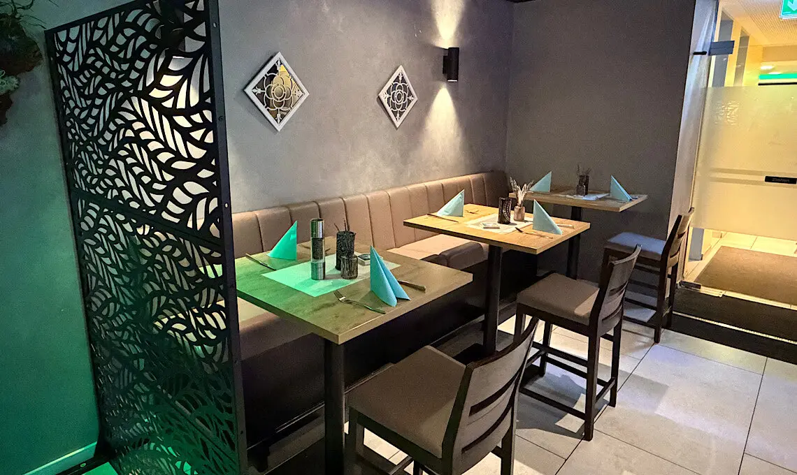 Eingedeckte Tische im Restaurant Marmaris mit Lounge-Bank und Trennwand